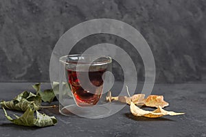 Ð glass in the form of a skull on the Halloween on a dark background with dry leaves