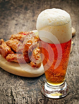 Glass of fresh beer and fried chicken wings