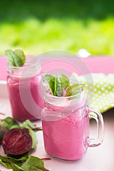 Glass of fresh beetroot juice with bets and leafs . Beetroot smoothie in jar. Pink detox.