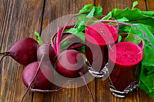 Glass of fresh beetroot juice with bets on wooden