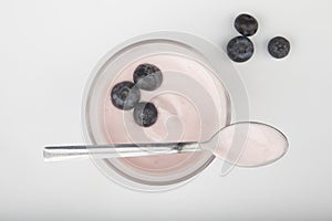 Glass of fresh berries and yogurt on white background