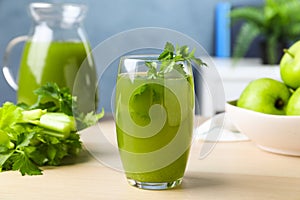 Glass of fresh celery juice on white table, closeup