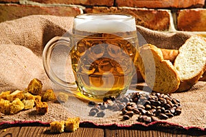 A glass of fresh cold light beer with bread on burlap