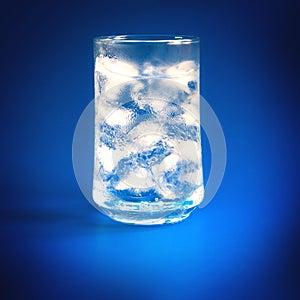 A glass of fresh cool water and ice cubes