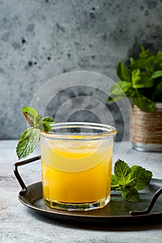 Glass of fresh golden watermelon juice or smoothie with slices of watermelon. Refreshing cold summer fruit drink.