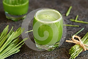 A glass of fresh green barley grass juice on a table