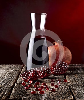 Glass of fresh healthy pomegranate juice, ripe pomegranate and clipping path with red seeds on wooden background