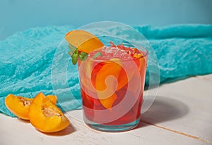 Glass with fresh homemade peach sweet iced tea or cocktail, lemonade with mint. Marine theme. Refreshing cold drink