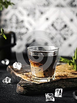 Glass of fresh iced coffee on a wooden tray