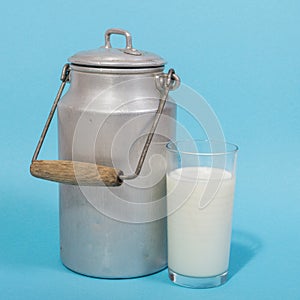 Glass of fresh milk and milk canister