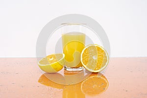 Glass of fresh orange juice with fresh fruits on white background