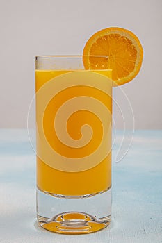 Glass of fresh orange juice with fresh fruits on wooden table