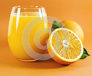 Glass of fresh orange juice with fruits cut in half and sliced with green leaf isolated on white background, clipping path