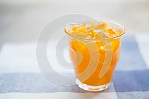 Glass of fresh orange juice with ice cubes