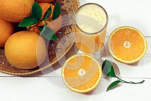 A glass of fresh orange juice and orange fruits on a wooden table. Healthy food