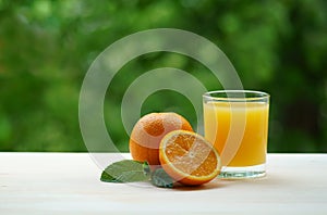 A glass of fresh orange juice with a slice of orange and mint leaves