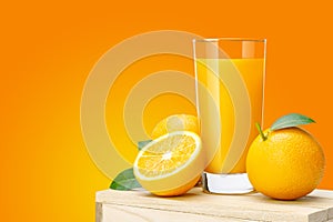 Glass of fresh orange juice on wooden box, Fresh fruits Orange juice in glass with group on orange color background with copy