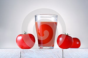 Glass of fresh organic tomato juice with raw tomatoes