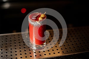 Glass of fresh salty red tomato bloody mary cocktail decorated with salt and olives