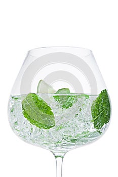 Glass of fresh sparkling water lemonade with mint and ice cubes on white background. Macro
