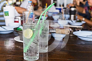 Glass of fresh sparkling water with slice of lime on table.