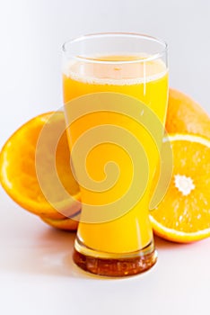 Glass with fresh squeezed orange juice and oranges on white healthy life concept