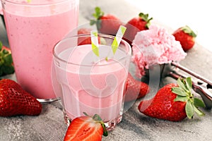 Glass of fresh strawberry shake, smoothie or milkshake and fresh strawberries on table. Healthy food and drink concept