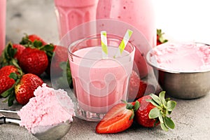 Glass of fresh strawberry shake, smoothie or milkshake and fresh strawberries on table. Healthy food and drink concept