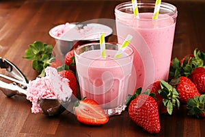 Glass of fresh strawberry shake, smoothie or milkshake and fresh strawberries on table. Healthy food and drink concept