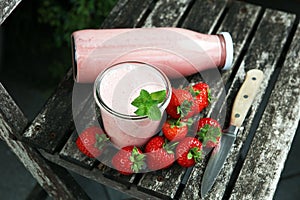 Glass of fresh strawberry shake, smoothie or milkshake and fresh strawberries on table. Healthy food and drink concept