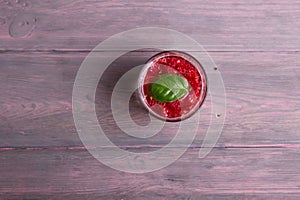 Glass of fresh strawberry smoothie and fresh strawberries on pink wooden background. Healthy food and drink concept