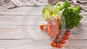 Glass of fresh tomato juice. Juice, cucumber, celery sticks and seasonings on a wooden background. Copy space