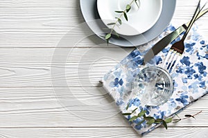 Glass of fresh water with dishware on white wooden table