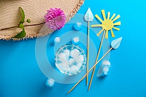 Glass of fresh water with ice cubes and decorations on color table