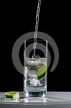 Glass of fresh water with ice and a slice of lime or lemon