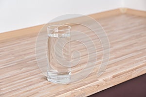 Glass with fresh water on table in kitchen