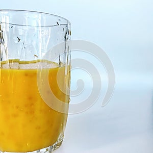 A glass of fresh yellow smoothie. Summer and tropical smoothies. Cold blended drinks, fruit smoothie.