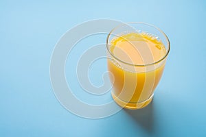 Glass of Freshly Pressed Orange Citrus Juice on Light Blue Background. Freshness Healthy Drink Detox Breakfast Morning