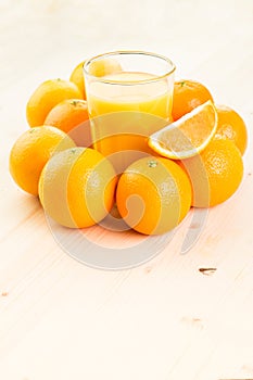 Glass of freshly pressed orange juice with oranges