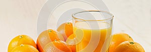 Glass of freshly pressed orange juice with oranges