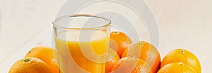 Glass of freshly pressed orange juice with oranges