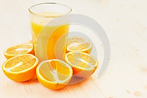 Glass of freshly pressed orange juice with sliced orange halfs