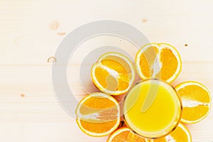 Glass of freshly pressed orange juice with sliced orange halfs