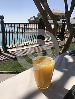 A glass of freshly squeezed orange juice on a restaurant terrace overlooking the sea