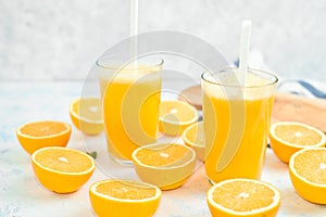 Glass of freshly squeezed orange juice and slices of orange fruit isolated on white background