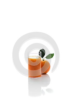 A glass of freshly squished orange juice with orange on side photo
