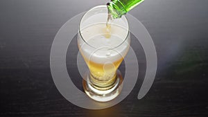 Glass of frothy fresh beer on table