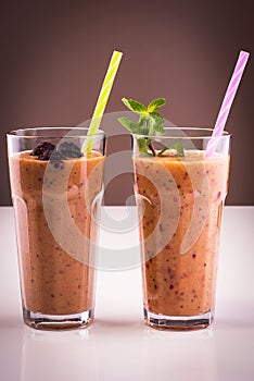 Glass of frozen and fresh fruits smoothie with mint and straw