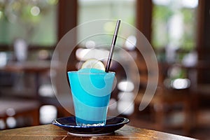 A glass of Frozen margarita cocktail with lime juice, blue grenadine and soda.