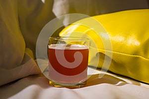 A glass of fruit beer on bed